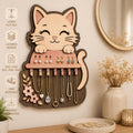 Cute cat jewelry holder SVG laser cut file featuring layered wood design, earring display, necklace organizer hooks, floral accents, and decorative wall-mounted storage.