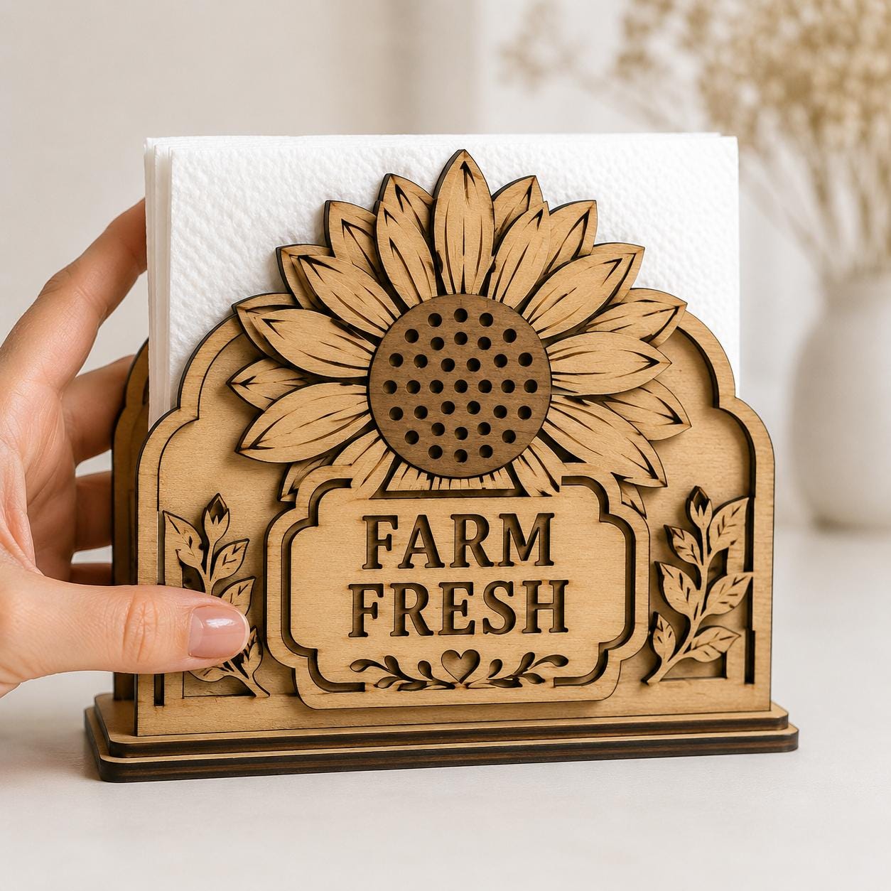 Farm Fresh sunflower napkin holder displayed on a kitchen countertop, featuring detailed layered wood elements. Digital SVG laser cut file for farmhouse kitchens, dining tables, and handmade gifts.