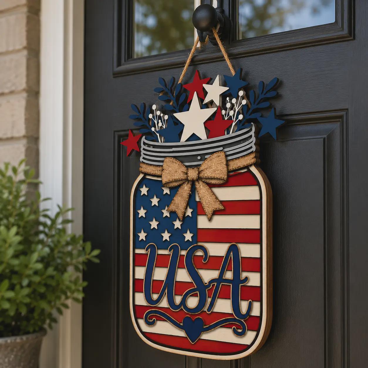 USA American Flag Mason Jar door hanger displayed on a black front door, layered laser cut patriotic decoration perfect for 4th of July, Memorial Day, and Americana decor.